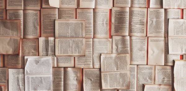 Open access books and academic papers displayed on a wall.
