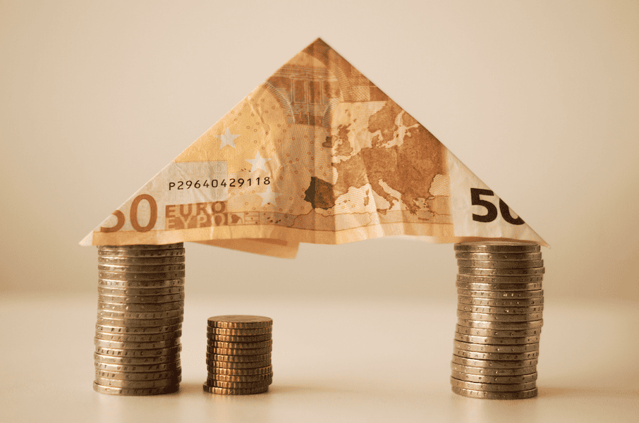 Creative image of a house made from euro banknotes and coins.
