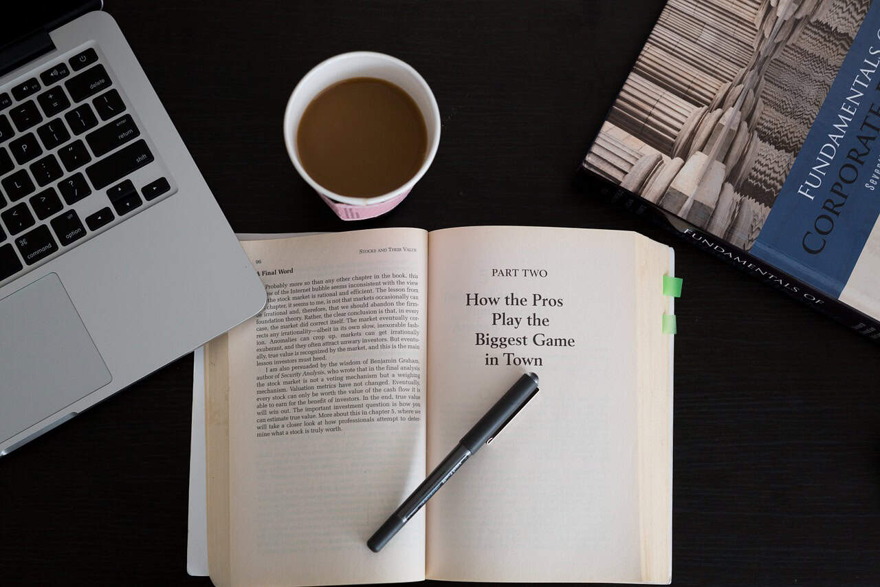 Modern workspace with laptop, open book, and coffee for business or study.
