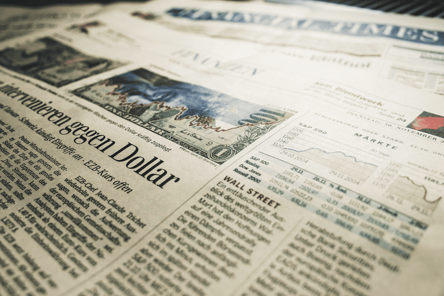 Financial newspaper with stock market and economic news headlines.